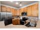 Modern kitchen featuring wooden cabinets, stainless steel appliances, and ample countertop space at 341 Granby Way # A, Aurora, CO 80011