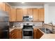 Updated kitchen showcasing stainless steel appliances, wooden cabinets, and stylish countertops at 341 Granby Way # A, Aurora, CO 80011