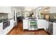 Bright kitchen featuring stainless steel appliances, white cabinetry, and dark countertops at 3315 N Stuart St, Denver, CO 80212