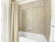 A shower/tub combo with a neutral-colored tile surround and a white shower curtain rod at 7633 S Addison Way, Aurora, CO 80016