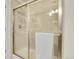Modern bathroom with a glass-enclosed shower featuring tile walls, a shower caddy and white towel at 7633 S Addison Way, Aurora, CO 80016