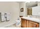 Neutral bathroom features a wood cabinet, a white countertop, and a framed picture on the wall at 7633 S Addison Way, Aurora, CO 80016
