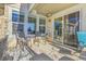 Relax on this covered patio featuring neutral chairs and convenient access through a sliding glass door at 7633 S Addison Way, Aurora, CO 80016
