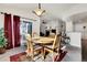 Cozy dining area with a round wooden table and four chairs, flowing into an open-concept living space at 7633 S Addison Way, Aurora, CO 80016