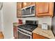Close-up of kitchen featuring stainless steel oven, microwave, and granite countertops at 7633 S Addison Way, Aurora, CO 80016