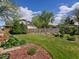 Backyard featuring a lush lawn, garden beds, mature trees, and a charming fence at 4175 S Sidney Ct, Denver, CO 80237