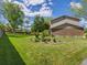 Expansive backyard with lush lawn, mature trees, and partial view of the home's exterior at 4175 S Sidney Ct, Denver, CO 80237