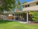 The backyard features a covered patio, outdoor dining area, lawn, and access to the garage at 4175 S Sidney Ct, Denver, CO 80237