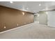 Unfurnished basement features neutral carpeting, contrasting brown accent wall and white trim at 4175 S Sidney Ct, Denver, CO 80237