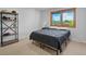 Neutral bedroom features large window and simple furnishings at 4175 S Sidney Ct, Denver, CO 80237