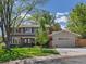Two-story home with a well-kept lawn, mature trees, a driveway, and stone accents at 4175 S Sidney Ct, Denver, CO 80237