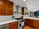 Modern kitchen with a stainless steel range hood, custom cabinets, and a white backsplash at 4175 S Sidney Ct, Denver, CO 80237