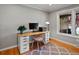 Bright home office with hardwood floors, a large window, and a modern desk setup at 4175 S Sidney Ct, Denver, CO 80237
