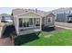 Aerial view of a covered patio with outdoor seating and a grill overlooking the manicured lawn at 10553 Xenia Ct, Commerce City, CO 80640
