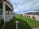 Beautifully landscaped backyard with a spacious lawn, mature trees, and a charming covered patio at 10553 Xenia Ct, Commerce City, CO 80640