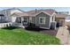 Aerial view of backyard featuring a covered patio with a grill, lawn, and dark mulch at 10553 Xenia Ct, Commerce City, CO 80640