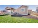 Well-maintained backyard with a covered patio, lush lawn, and dark mulch at 10553 Xenia Ct, Commerce City, CO 80640