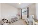 Bedroom featuring a crib, rocking chair, and ample natural light, creating a serene and welcoming space at 10553 Xenia Ct, Commerce City, CO 80640