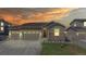 Charming one-story home featuring a three-car garage, bathed in a beautiful sunset at 10553 Xenia Ct, Commerce City, CO 80640