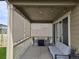 Covered patio area with comfortable seating, string lights, and privacy shades at 10553 Xenia Ct, Commerce City, CO 80640