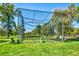 Outdoor driving range area with netting, artificial turf, seating, and surrounding trees at 13631 E Marina Dr # 502, Aurora, CO 80014