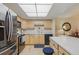 Bright kitchen features wood cabinets, white counters, stainless steel appliances, and a unique decorative clock at 13631 E Marina Dr # 502, Aurora, CO 80014