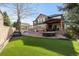 Expansive backyard with lush green lawn, covered patio with outdoor seating, and pool at 10700 Addison Ct, Highlands Ranch, CO 80126