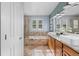 A bright bathroom with a soaking tub, dual sinks, wood cabinets and shuttered windows at 10700 Addison Ct, Highlands Ranch, CO 80126