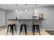 A well-appointed wet bar area with modern pendant lighting and sleek bar stools at 10700 Addison Ct, Highlands Ranch, CO 80126