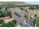 Aerial view of a commercial building surrounded by lush greenery, streets, and mountain scenery at 615 24Th St # 103, Golden, CO 80401