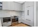 Modern kitchen featuring stainless steel appliances, clean white cabinetry and light wood flooring at 1601 Park Ave # 202, Denver, CO 80218