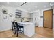 Modern kitchen with sleek island, stainless appliances, white cabinetry, and hardwood floors at 1601 Park Ave # 202, Denver, CO 80218