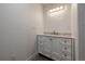 Well-lit bathroom featuring a stylish vanity with marble countertop and ample storage, offering a functional space at 69101 E 72Nd Ave, Byers, CO 80103
