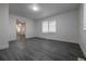 Well-lit living room with gray flooring, large windows, and an open doorway leading to other areas of the house at 69101 E 72Nd Ave, Byers, CO 80103