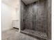 Modern shower with unique stone flooring and tiled walls, next to a vanity, designed for a luxurious experience at 69101 E 72Nd Ave, Byers, CO 80103