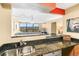 Modern kitchen featuring granite countertops, stainless steel appliances, breakfast bar, and open access to living area at 1020 15Th St # 16A, Denver, CO 80202