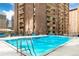 Outdoor pool with clear blue water, surrounded by a deck and high-rise building views at 1020 15Th St # 16A, Denver, CO 80202