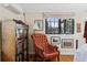 A cozy bedroom featuring a tufted armchair, a bookshelf and natural light from the window at 357 Birch St, Denver, CO 80220