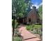 Charming brick home with a lush garden, stone walkway, chimney and arched entry at 357 Birch St, Denver, CO 80220