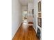 Long hallway with hardwood floors, white walls, and decorated with framed pictures at 357 Birch St, Denver, CO 80220