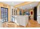 Sunlit kitchen with white cabinets, center island with barstool seating, and a stainless steel dishwasher at 357 Birch St, Denver, CO 80220