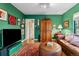 Comfortable living room with green walls, hardwood floors, and a cozy leather sofa at 357 Birch St, Denver, CO 80220