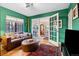 Cozy living room with green walls, hardwood floors and comfortable seating at 357 Birch St, Denver, CO 80220