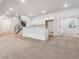Large basement area featuring a wet bar and adjacent stairs with metal railing, providing a functional living space at 8658 Pennycress Dr, Littleton, CO 80125