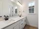 Modern bathroom featuring double sinks, a large mirror, and a bright window at 8658 Pennycress Dr, Littleton, CO 80125
