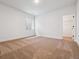 Minimalist bedroom with neutral carpet and trim; complemented by a window and closet, ready for customization at 8658 Pennycress Dr, Littleton, CO 80125