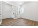 Bright bedroom featuring wood floors, white walls, large window, and a stylish glass panel door at 8658 Pennycress Dr, Littleton, CO 80125