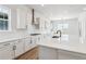 Kitchen island featuring a black sink, white countertops, and a subway tile backsplash at 8658 Pennycress Dr, Littleton, CO 80125