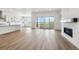 Spacious open-concept living room featuring wood floors, a cozy fireplace, and sliding doors to the outside at 8658 Pennycress Dr, Littleton, CO 80125