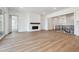 Open-concept living room featuring wood floors, a cozy fireplace, and seamlessly integrates with the kitchen and staircase at 8658 Pennycress Dr, Littleton, CO 80125